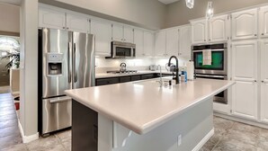 A modern kitchen with white cabinetry, stainless steel appliances, and a large island. - Corparate executive and Luxury family 4-bedroom house in lovely Henderson (Henderson)