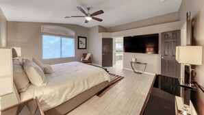 A modern bedroom with a bed, ceiling fan, TV, and a small table. - Corparate executive and Luxury family 4-bedroom house in lovely Henderson (Henderson)