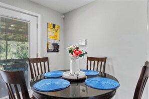 A dining table with four blue placemats, a vase with flowers, and two wooden chairs. - Peaceful hilltop country living, 10 mins to stores (Barnhart)