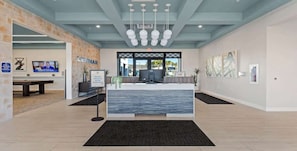 A reception area with a modern design, a reception desk, a television, and artwork on the walls. - Classy 6BR Home with Private Pool (Kissimmee)