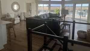 A spacious living room with a large window, a ceiling fan, and a view of a field. - Waterfront Bay Views, Private Pool, 6 Bedroom, Pet-Friendly! Sleeps14 (Virginia Beach)