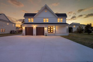 A two-story house with a garage, a front porch, and a driveway. - Waterfront Bay Views, Private Pool, 6 Bedroom, Pet-Friendly! Sleeps14 (Virginia Beach)