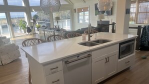A modern kitchen with a large island, double sink, and built-in microwave. - Waterfront Bay Views, Private Pool, 6 Bedroom, Pet-Friendly! Sleeps14 (Virginia Beach)