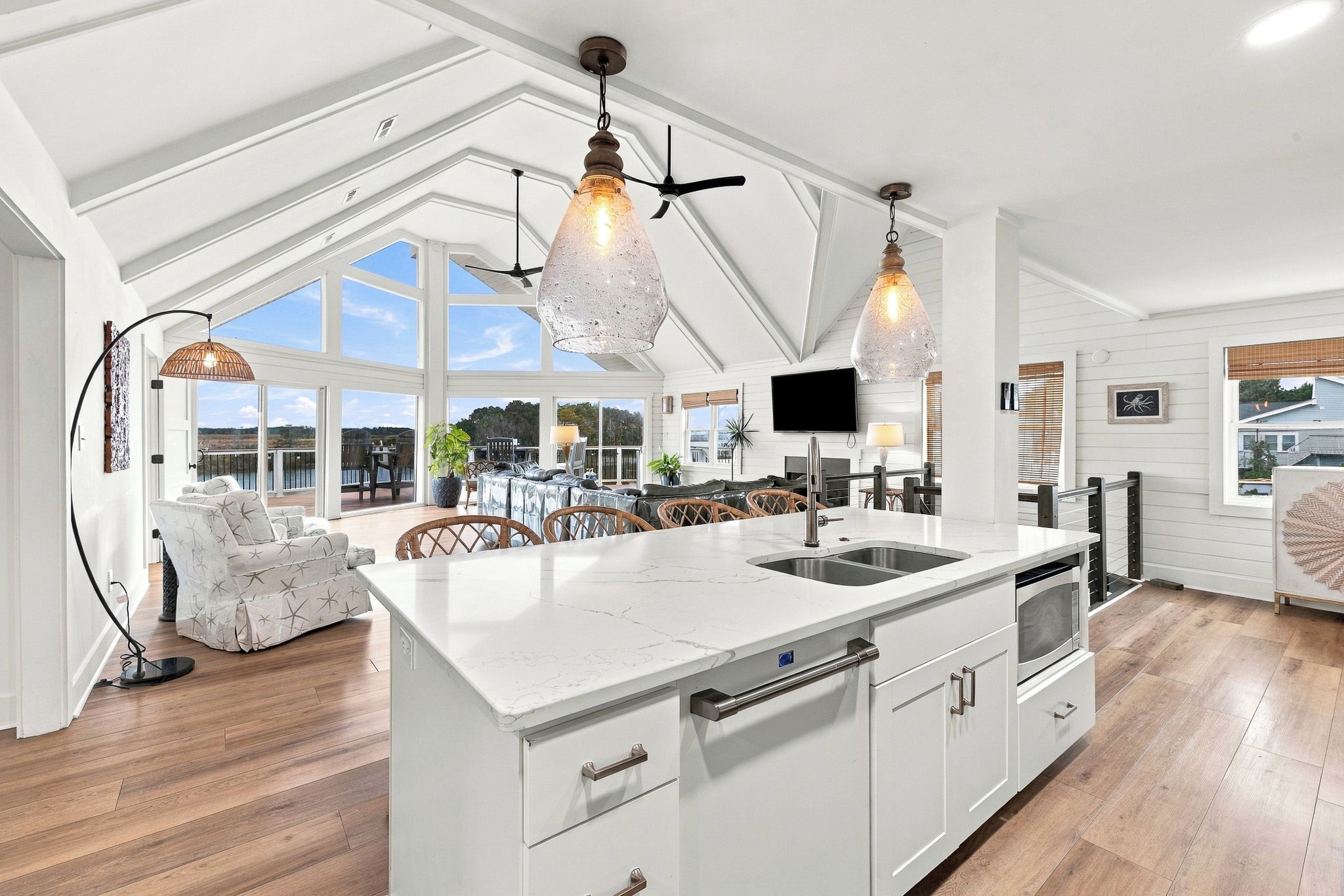 A spacious kitchen with a large island, pendant lighting, and a view of the outdoors.