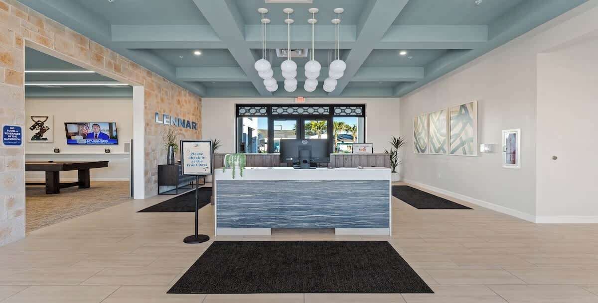 A reception area with a counter, a television, and artwork on the walls.