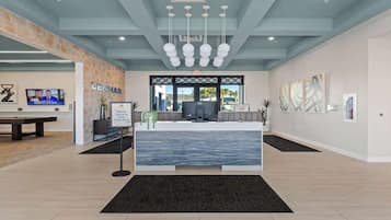 A reception area with a counter, a television, and artwork on the walls.