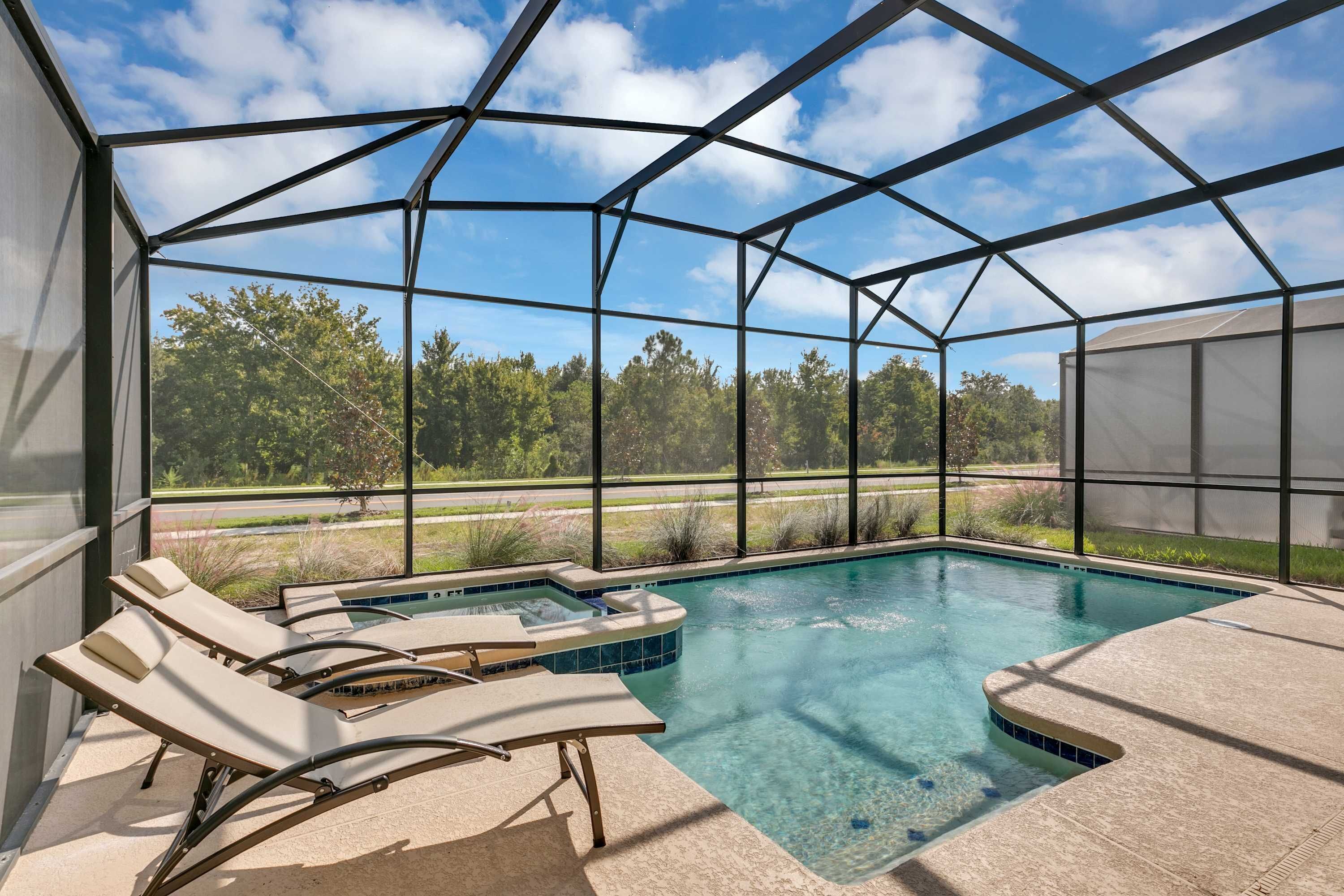 Una piscina exterior cubierta con sillones de descanso, un jacuzzi y vistas a un jardín ajardinado.