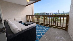 Un balcon avec un canapé, une table et un ventilateur de plafond.