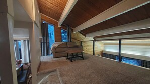 A spacious attic room with a high ceiling, a cozy sofa, and a dining area. - Chilling in the Boat! Location, Comfort & Style (Steamboat Springs)