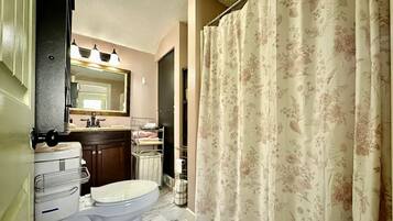 Chuveiro, toalhas de banho, sabonete, papel higiênico