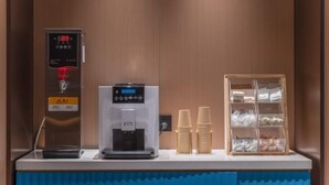 A self-service station with a water dispenser, a coffee machine, and a cup holder area. - Yisitin Hotel (Taiyuan North Zhonghuan Street Zoo) (Taiyuan)