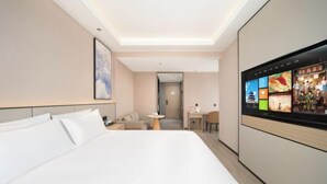 A hotel room with a large bed, a TV on the wall, a desk, and a small seating area. - Yisitin Hotel (Taiyuan North Zhonghuan Street Zoo) (Taiyuan)