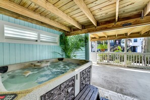 Un espace avec un jacuzzi, doté d’un plafond en bois et offrant une vue sur une rue résidentielle.