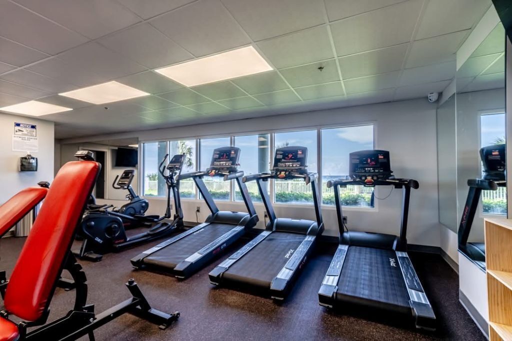 A gym with treadmills, a red exercise chair, and a stationary bike.