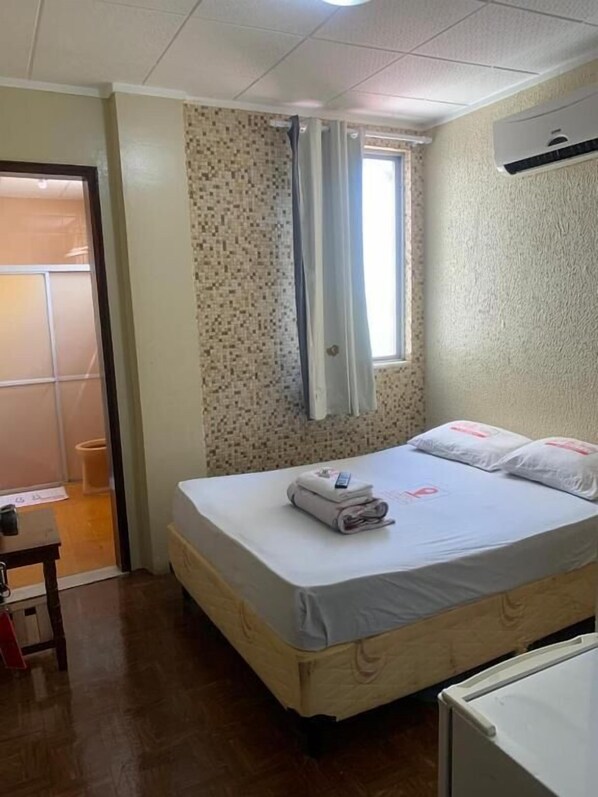A small, neatly arranged bedroom with a single bed, a bedside table, and a window with curtains. - HOTEL BELCENTRO (Belém)
