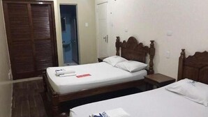 A room with two beds, wooden headboards, a wooden wardrobe, and a bathroom door. - HOTEL BELCENTRO (Belém)