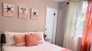 A bedroom with a bed, three wall-mounted starfish artwork, a door, and a window with curtains. - Coral Cottage Cove-Amazing Ocean Views - 3 Bedroom 2 Bath in St. Thomas (St. Thomas)