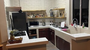 Une cuisine moderne avec des murs en briques blanches, des armoires en bois et un îlot central.