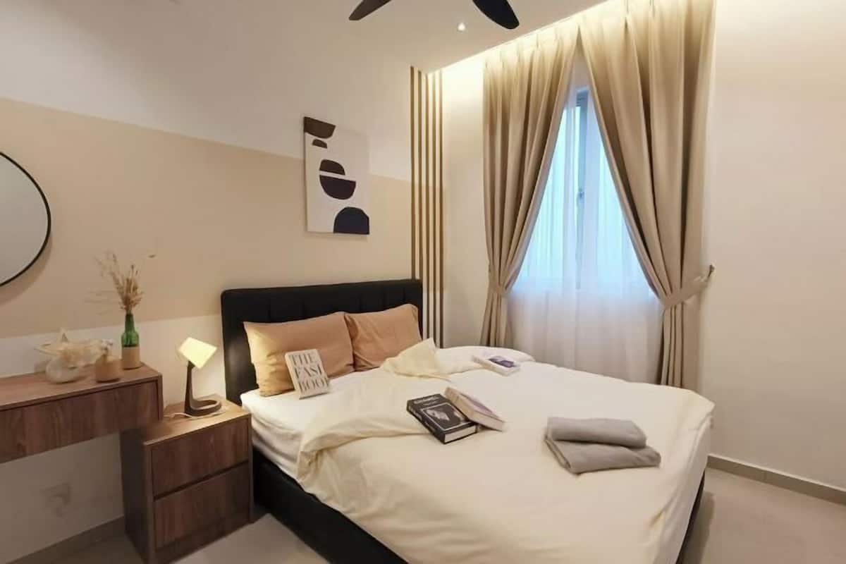A bedroom with a bed, bedside table, lamp, and a wall art piece.