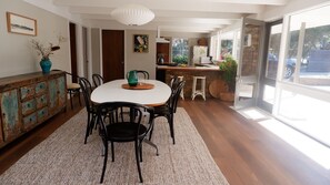 A dining area with a round table, chairs, and a rustic wooden cabinet.