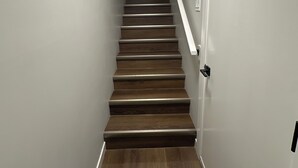 Una escalera con escalones de madera y paredes blancas.