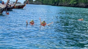 Klares Blick auf ein Gewässer mit Booten und schwimmenden Menschen.