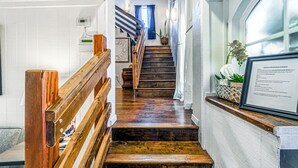 A wooden staircase with a handrail, leading to a landing with a framed welcome sign. - Mountain Top House with a View - Elk House (Ruidoso)