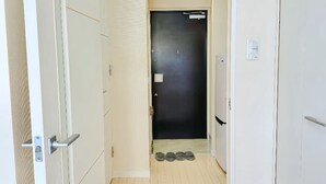 A narrow hallway with a dark door at the end, a light switch on the wall, and a small set of shoes on the floor. - Kinshicho Station, sightseeing area ・Near Tokyo Skytree and Asakusa, sightseeing area ・Direct access to airport (墨田区太平2－9－5)