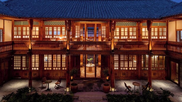 Ein traditionelles koreanisches Gebäude mit Holzarchitektur, einem Innenhof und Sitzbereichen.