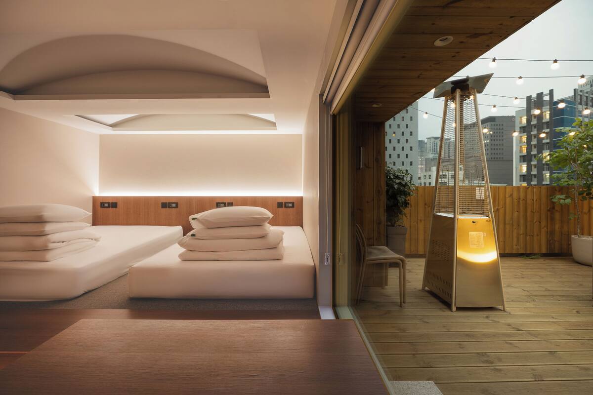 A modern bedroom with a bed, bedside tables, and a heater.