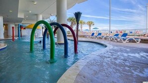 Ein Poolbereich mit bunten Wasserrutschen und Liegestühlen.