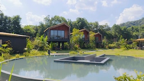 A modern resort with wooden cabins, a central pool, and lush greenery. - Wanluhu Xingyue Homestay (Heyuan)