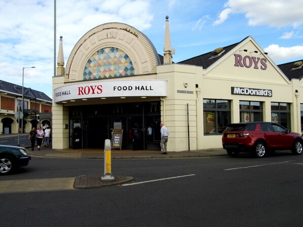 A building with a sign that reads "ROYS FOOD HALL" and "McDonald's" on the right side.