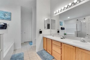 Un baño moderno con un tocador amplio, lavamanos dobles y un espejo con iluminación.