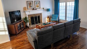 Una sala de estar con chimenea, televisor y sofá.