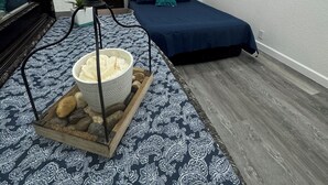 Quarto com uma cama, mesa de cabeceira com abajur, taça de sorvete e espelho.