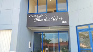 Un edificio moderno con un cartello che riporta la scritta "CONDOMÍNIO Ilha dos Lobos 100".