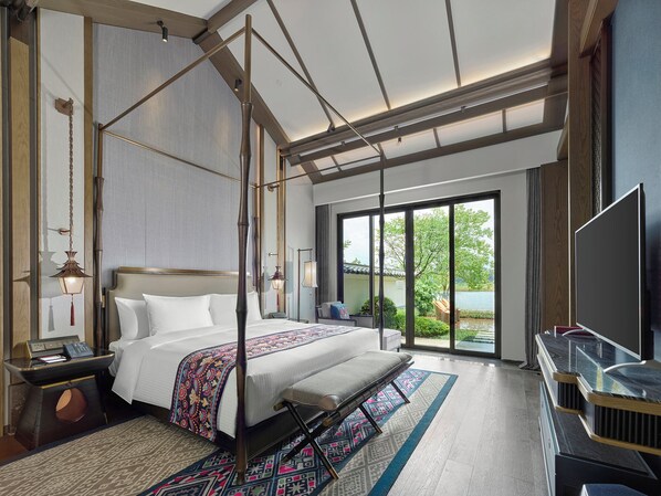 A modern hotel room with a four-poster bed, a flat-screen TV, and a large sliding glass door to the outdoors. - Song Hotel Guilin (Guilin)