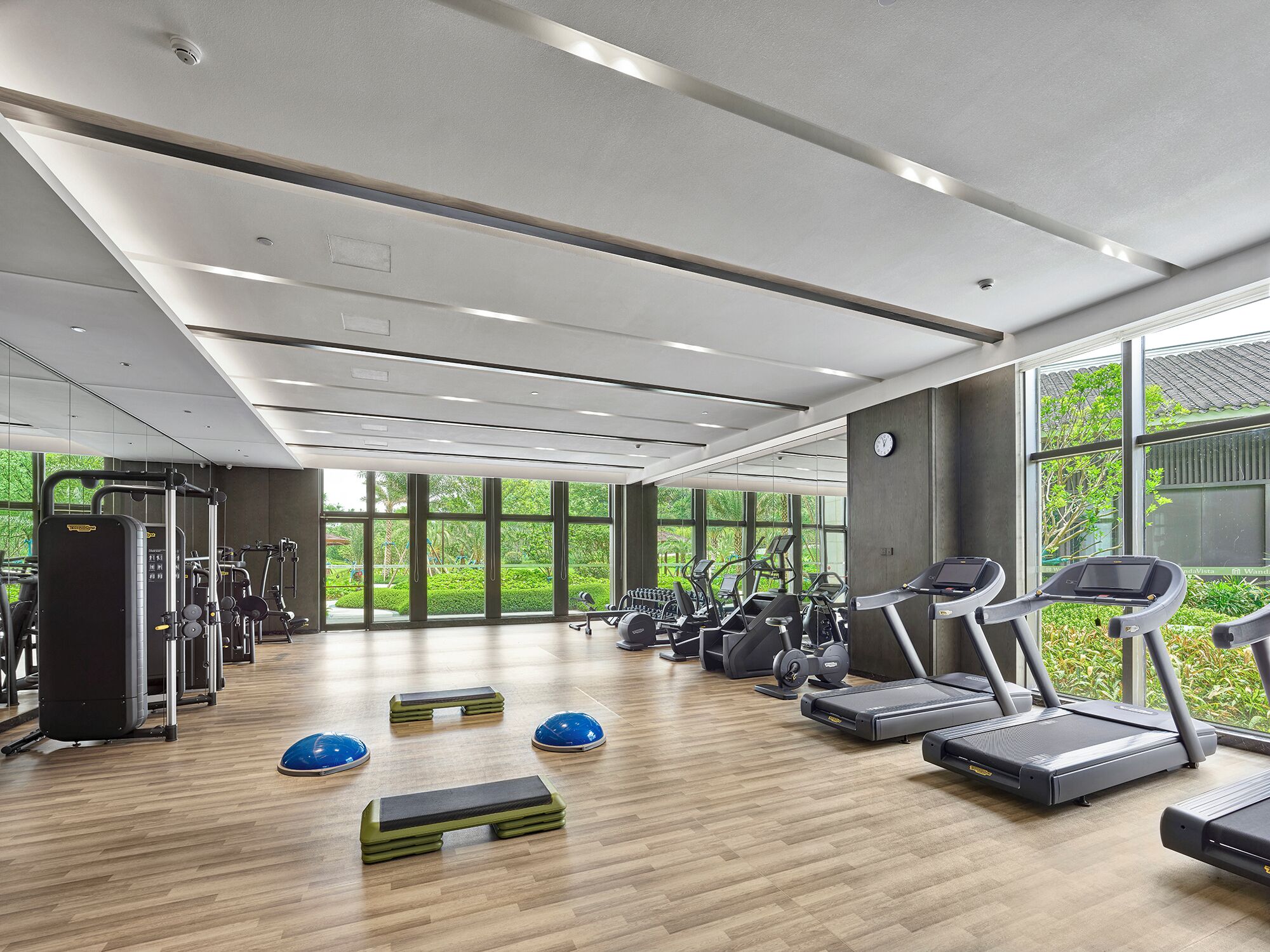 A gym with treadmills, elliptical machines, and weightlifting equipment.