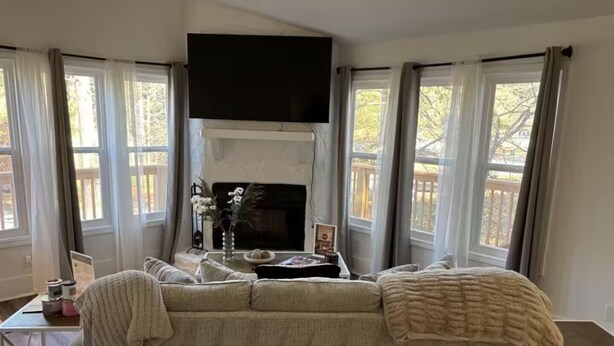 Ein gemütliches Wohnzimmer mit Kamin, einer Couch und einem Fernseher.