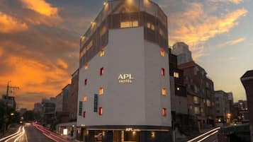 A hotel with a modern design, featuring a prominent APL HOTEL sign on the facade.