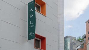 A building with a vertical sign reading 'APL HOTEL' and two small windows with orange frames. - Sinchon APL Hotel (Seoul)