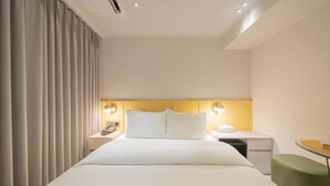 A hotel room with a large bed, bedside lamps, a desk, and a chair. - Sinchon APL Hotel (Seoul)
