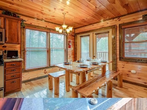 Ein rustikales Holzhaus-Interieur mit Esstisch, Bänken und einer Kristallleuchter.