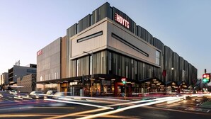 Een modern hotel met een opvallend 'HOYTS' bord, uitgevoerd in een eigentijds ontwerp met grote ramen en een plat dak.