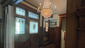 Un interior de madera con un candelabro, pisos de madera y una escalera.