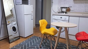 A compact kitchen with a microwave, toaster, and kettle. There is a washing machine, a sink, and a small dining table with two chairs. - 북한산이 가깝고  , 명동 까지 40분. 조용하고 편안한 숙소. (Seoul)