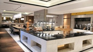A modern kitchen with a central island, built-in appliances, and a dining area with a long table and chairs. - The Hotel V Hongqiao  (Shanghai)