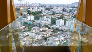 Un grattacielo con un balcone in vetro che si affaccia sulla città.