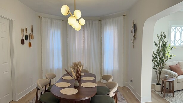 A dining room with a round table, six chairs, a vase with dried plants, and a chandelier. - Stylish 3BR Revere Home|Sleeps 8|Near Boston&Beach (Revere)